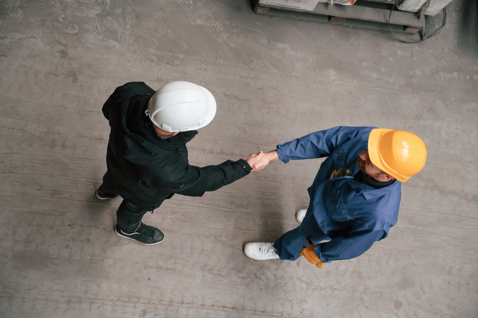vecteezy-two-industrial-workers-are-doing-handshake-top-view-59178493